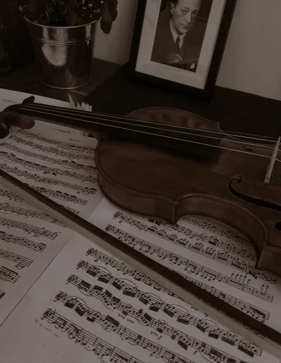 Violon et archet posés sur des partitions ouvertes
